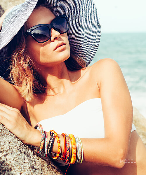Woman in a floppy hat at the beach