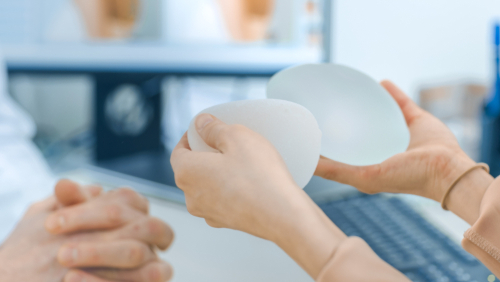 cosmetic surgeon shows female patient breast implant samples for her future surgery-img-blog